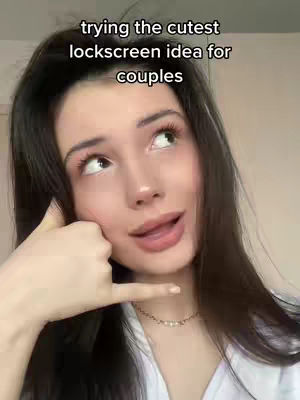 A woman with long dark hair is in a medium shot, looking up slightly with a soft expression and parted lips. She holds up her hand making a 'call me' gesture. Text is added to the image, set against a plain background.