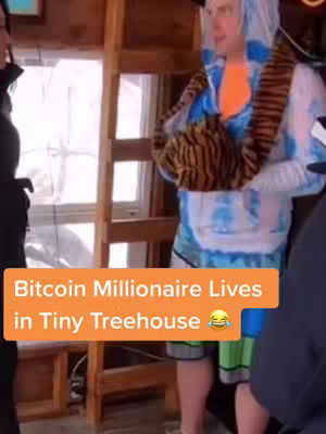 The cover image shows a man standing inside a wooden structure that appears to be a treehouse. He is smiling and wearing a blue-and-white tie-dye hooded jacket with an orange shirt underneath. A brown-striped vest is around his neck. The text overlay across the bottom highlights the title of the video.