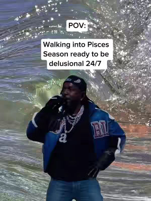 A man in a black cap and jacket stands in front of a wavy background resembling water. Text overlays are present, communicating a humorous message about Pisces season. The composition is centered, and the lighting suggests a studio or stage setting.