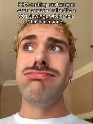 A close-up shot of a young man with light hair and a mustache, looking up and to his left with a slightly pouting expression. Overlayed text at the top of the image provides context.