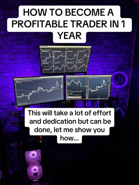 The image is a vertical shot of a desk setup with multiple computer monitors. The background features a purple brick wall. The main focus is on three screens displaying what appears to be stock or financial charts, with lines and graphs showing market data. There are two lines of text on top of the monitors contained in a white box: 'HOW TO BECOME A PROFITABLE TRADER IN 1 YEAR'. Another text area in white is present below the monitors, containing the text 'This will take a lot of effort and dedication but can be done, let me show you how...'. The desk has a computer tower with illuminated lights, positioned below the screens. The overall composition suggests a tutorial or educational content about trading.