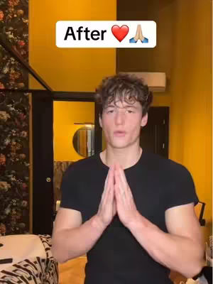 A young man in a black crew-neck t-shirt stands indoors with his hands pressed together in a prayer position. Behind him, the wall is yellow, and the background includes a glimpse of a dark frame, possibly a door or another room. The top of the image has a white rectangular overlay with the word 'After' and emojis.