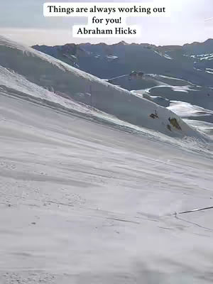 A snowy mountain landscape with a text overlay in the top left corner. The image is dominated by the white and gray of the snow and mountains under a bright sky.