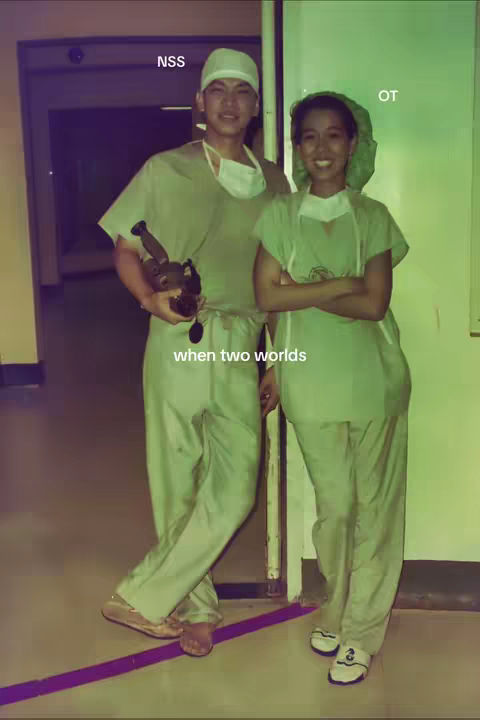 Cover image shows two people, a man and a woman, both wearing medical scrubs and caps, standing close together. They are in a brightly lit environment, possibly a hospital room or hallway. The man is holding a small, dark-colored object, possibly a medical instrument. The woman is smiling. The background is a soft green and the color palette is muted, giving a sense of professionalism and collaboration.