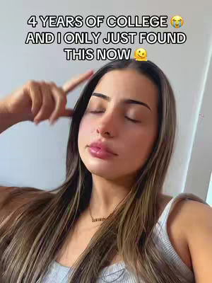A selfie-style video cover image shows a young woman indoors. She has long, straight brown hair, and is wearing a light-colored tank top. The background is a light, plain wall. In the foreground, the woman has her eyes closed and is touching her temple with her index finger. Overlay text at the top reads, "4 YEARS OF COLLEGE 😭 AND I ONLY JUST FOUND THIS NOW 🤔". The overall composition is simple and focuses on the woman's expression with muted tones.