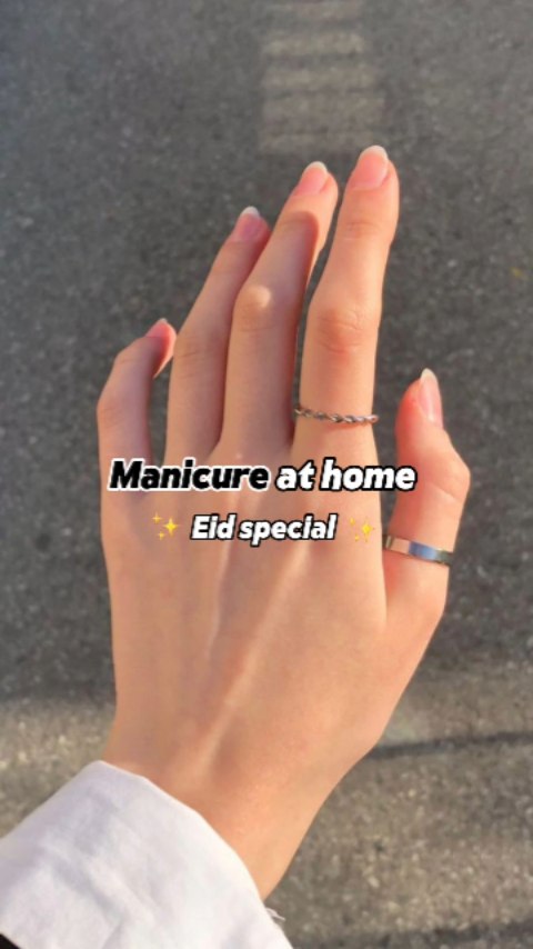 A hand with well-manicured nails, adorned with rings, is displayed against a blurred grey concrete background. Text overlays indicate the video's theme.