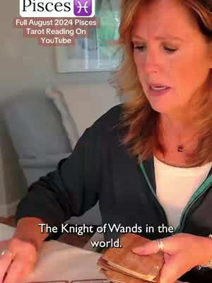 A woman with auburn hair is seated, holding a deck of cards related to tarot. The image has a soft, natural light and a focus on the woman's expressive face. Overlay text indicates the video's focus on a Pisces tarot reading.