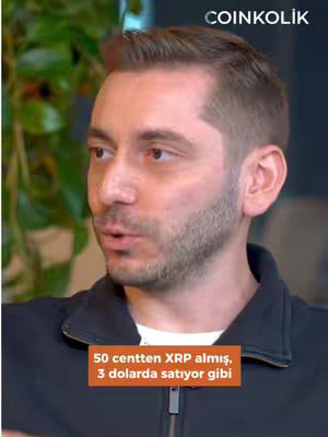 The cover image features a man in a medium close-up view, focusing on his face and upper torso. He is looking slightly to the side and speaking, with his mouth open. The background is blurred, suggesting a shallow depth of field. A text overlay at the bottom says, \"50 centten XRP almış, 3 dolarda satıyor gibi\" (as if he bought XRP for 50 cents and sold at $3). The overall color scheme leans towards natural tones with warm lighting, which directs attention to the speaker's face.