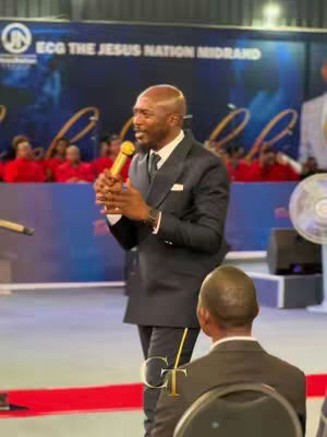 The cover image features a man in a dark suit speaking into a microphone with a golden head. He is standing on what appears to be a stage, and behind him is a banner with text and a logo.