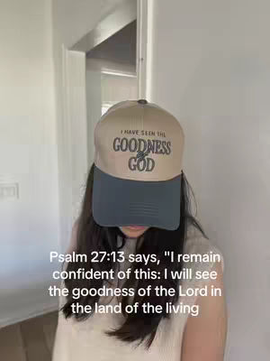 A person wearing a baseball cap with the text "I HAVE SEEN THE GOODNESS GOD", a white top and dark hair. A passage from Psalm 27:13 is at the bottom of the image.