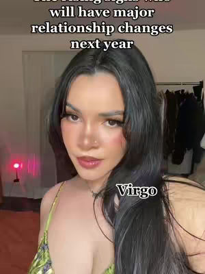 A selfie-style shot featuring a woman with long dark hair and makeup. Text overlays state astrological predictions. The background is a domestic setting, with soft lighting.