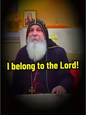 The video features a man with a long white beard and dark attire. The man is positioned in a room with a framed picture in the background, and text overlaid on him states, "I belong to the Lord!"