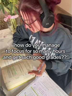 The cover image shows a person with red hair wearing glasses and headphones, studying at a table. There's a book open on the table with notes and a pen resting on the page. The person is wearing a dark gray long-sleeve shirt, and a vase with flower is partially visible. The text overlay asks the question: 'how do you manage to focus for so many hours and get such good grades??'.