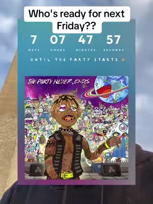 A person holding an image of a cartoon character that is wearing a vest and holding a pen, the image is on a countdown timer for a new album or song release. The background is purple with multiple characters and the earth with rings, the countdown is displayed at the top, the person is holding the image and a background wall can be seen.