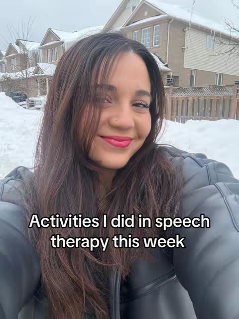 A young woman with long brown hair and pink lipstick smiles directly at the camera. She is wearing a black leather jacket, and the background shows a snowy suburban scene with houses. Text across the bottom of the image states, "Activities I did in speech therapy this week".