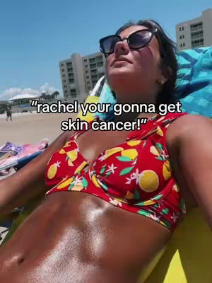 A woman is lying on a beach chair, basking in the sun. She is wearing sunglasses and a red and yellow floral bikini top. Her skin is deeply tanned and glistening, and the image has a bright and sunny feel. There is text overlayed on the image.