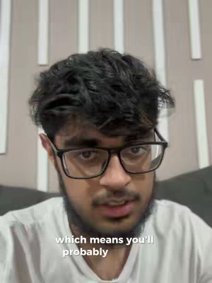 The cover image is a selfie-style shot of a young man with short, dark hair and a trimmed beard, wearing black-framed glasses and a white t-shirt. The background shows vertical, light-colored panels suggesting the setting is indoors. Text overlayed on the image reads 'which means you'll probably'. The composition centers on the man's face, implying a conversational or explanatory tone.