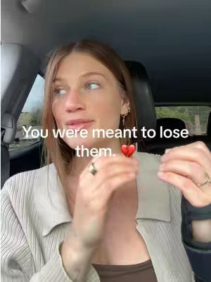 A woman in a car looks towards the left as if reacting to news. Text that reads "You were meant to lose them." appears over her image, and a red heart emoji is added.