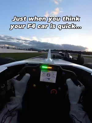 The cover image presents a first-person perspective from inside a race car. The image is focused on speed and the thrill of driving. The foreground displays the car's dashboard, steering wheel, and the driver's gloved hands. The background shows a race track with blurred surroundings, suggesting high speed. Text overlay indicates the video's thematic focus. The composition is dynamic, with a cool color palette enhancing the sense of movement and speed.
