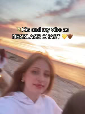 A woman with light-brown hair in a white hoodie is smiling towards the camera, with a sunset backgound. The text overlay says 'His and my vibe as NECKLACE CHART' over the image.