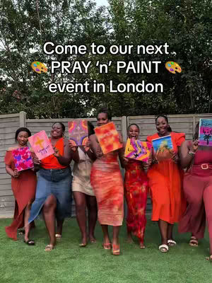 A group of women holding up colorful paintings in front of a lush green backdrop. The women are dressed in bright, vibrant colors, creating a lively and celebratory atmosphere. Text overlays on the image provide additional context.