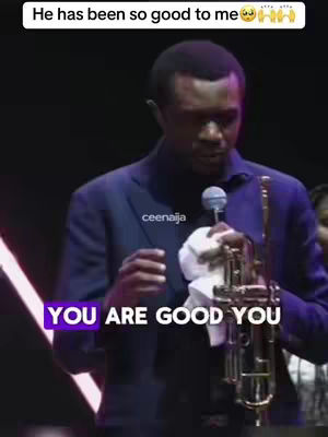 A man in a suit is holding a microphone and a trumpet. There is a purple text overlay on the bottom left that says "YOU ARE GOOD YOU". The background is dark, and the lighting appears to be from a stage.