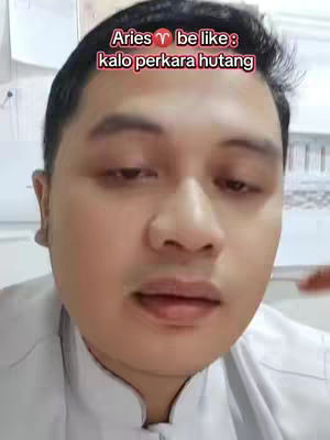 A medium shot features a light-skinned man's face close up in front of a light, nondescript background. He has dark hair and is looking slightly down. Text overlays at the top of the frame in red and white font, related to the zodiac sign Aries.