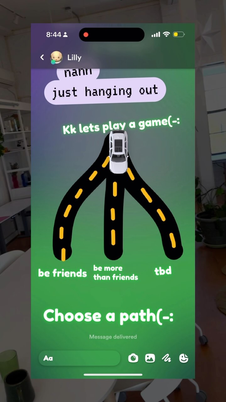 The cover image shows a phone screen displaying a digital art piece. It contains several text bubbles in a chat interface, and a road network with a car at the intersection where the user is prompted to choose an option and indicates that the current conversation is ‘more than friends’ with several emojis.