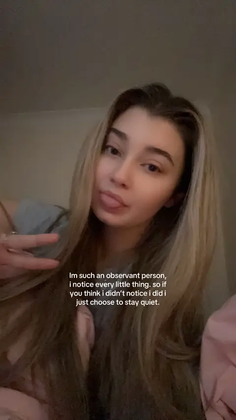 A selfie-style shot featuring a young woman with long blonde hair, her face angled slightly towards the camera. She's giving a peace sign with one hand and sticking out her tongue. Text is overlaid on the image.