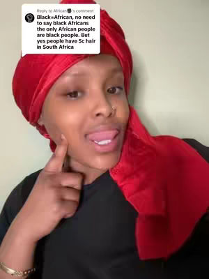A person with dark skin and a red headscarf is shown making a facial expression with one finger near the cheek, and words from a comment are overlaid on the image.