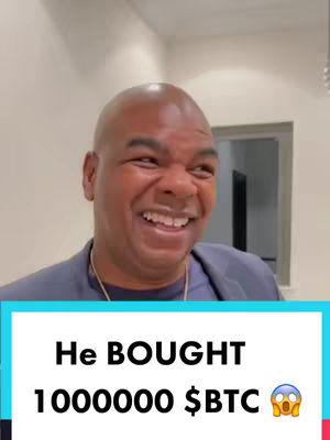 A man with a bald head is laughing, looking slightly to the side. He has a blue shirt and a gold chain. The background is an interior setting with white walls and a doorway. Below is a colored bar with white text overlaid.