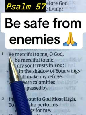 The image showcases an open book with a page from Psalms. Overlayed on top is a white speech bubble with large, bold black text that reads "Be safe from enemies". Below the text is a praying hands emoji. Above the text is a black rounded rectangle with white text that reads "Psalm 57".