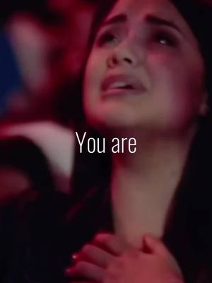 The cover image is a close-up shot of a woman with dark hair, who appears to be in distress, possibly crying. The background is blurred, suggesting a crowded area, with a dominant red lighting hue. Overlaid in white text, the words "You are" are positioned at the top, adding a direct message to the image.