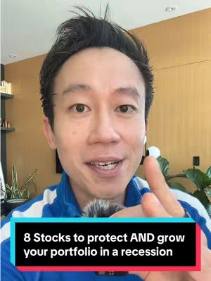 A man with short black hair is smiling directly towards the camera. Behind him, a warm-toned wood-paneled wall is visible. A text overlay at the bottom reads: "8 Stocks to protect AND grow your portfolio in a recession".