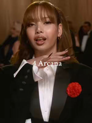 A medium shot of a woman in formal attire, a black suit over a white shirt, the sleeves rolled up. A red flower adorns the left lapel. Her left hand is raised towards her face with long, dark fingernails, while she looks directly at the camera with an open mouth expression. The text '4 Arcana' is overlaid on the image.