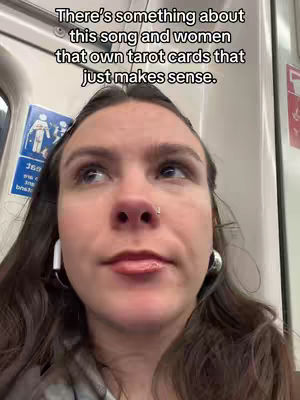 A woman with brown hair, wearing earrings and earbuds, looks up slightly in a selfie-style shot. Text overlay is at the top.