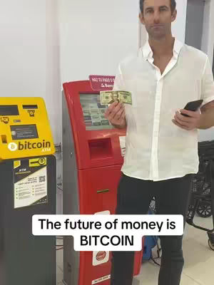 A man stands in front of two crypto ATMs, holding cash and a phone. The image emphasizes the business aspect of using crypto ATMs.