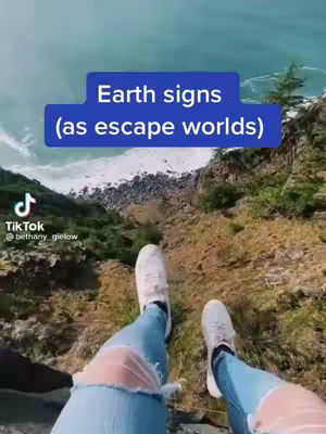 A first-person perspective looking down at the legs of a person with light blue jeans and white shoes sitting on a cliff overlooking the ocean. The text overlay says "Earth signs (as escape worlds)". The sky is blue, and the ocean is teal.