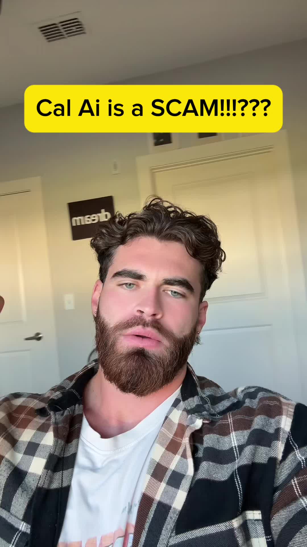 A man with a beard and a checkered shirt.