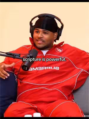 A man wearing a red tracksuit and headphones sits in front of a microphone. The text 'scripture is powerful' is overlaid on the image.