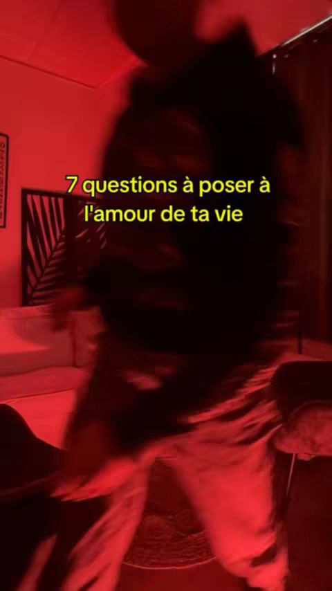 The cover image shows a blurred scene with a person in the foreground and a room in the background illuminated by red light. In the center, overlaid text in yellow states '7 questions à poser à l'amour de ta vie'.