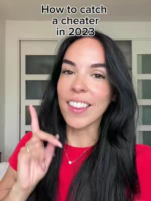 A woman with long, dark hair, wearing a red top, and is pointing her index finger in the air. The text overlay says "How to catch a cheater in 2023". The background has white doors.