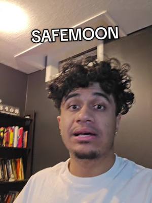 A young man with dark curly hair is looking at the camera with a slightly open mouth, above his head is text that says SAFEMOON.