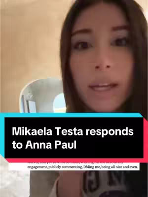 A selfie-style video with the creator front and center. The background is a blurred interior, likely a room. The creator, a woman with long dark hair, is looking at the camera and speaking. The video is framed with text at the bottom indicating the subject matter.