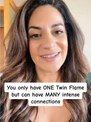 A selfie-style shot features a woman with long brown hair smiling directly at the camera. She has light skin, and her hair is styled with soft waves. The background is slightly out of focus, with hints of a room. The video has text overlay.