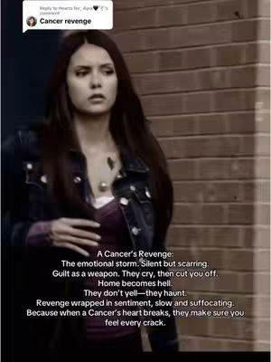 A woman with long dark hair, wearing a dark denim jacket over a purple top, stands in front of a tan brick wall, looking slightly off-camera. The background is blurred, and text overlays are present on the image.