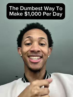 A selfie style shot of a young man smiling, with a text overlay at the top. The background appears to be a plain, light gray wall. The man is in a well-lit environment.