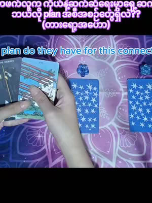 A hand holding tarot cards over a purple surface, with overlaid text in Burmese and English.