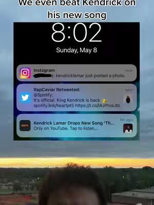 The image shows the top portion of a person's face, with notifications from Instagram and Twitter on the phone screen, the background is outdoors, possibly dawn or dusk.