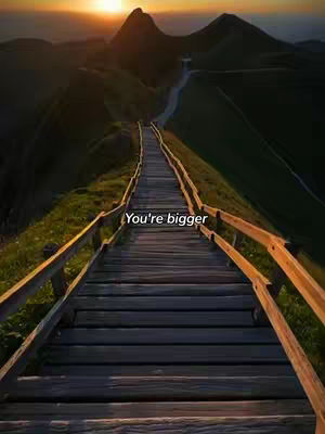 A scenic view of a wooden staircase leading upwards between green grassy hills to the horizon where the sun is setting. The text overlay is centrally placed across the stairs.